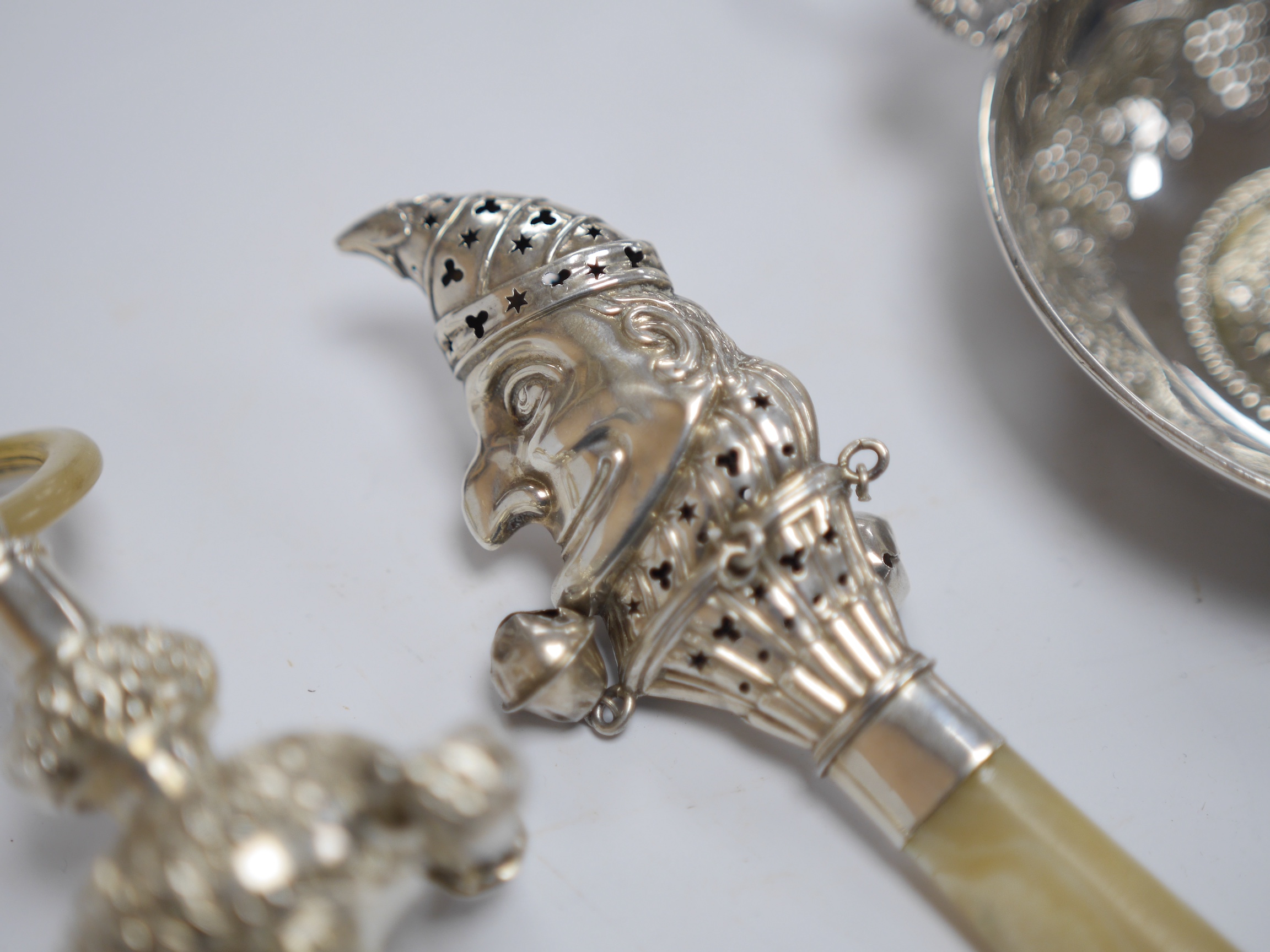 A George V silver and mother of pearl child's rattle, by Crisford & Norris, Birmingham, 1911, 15.2cm, one other sterling Mr. Punch rattle, a George V silver wine taster with fruiting vine decoration, a modern silver 6 in